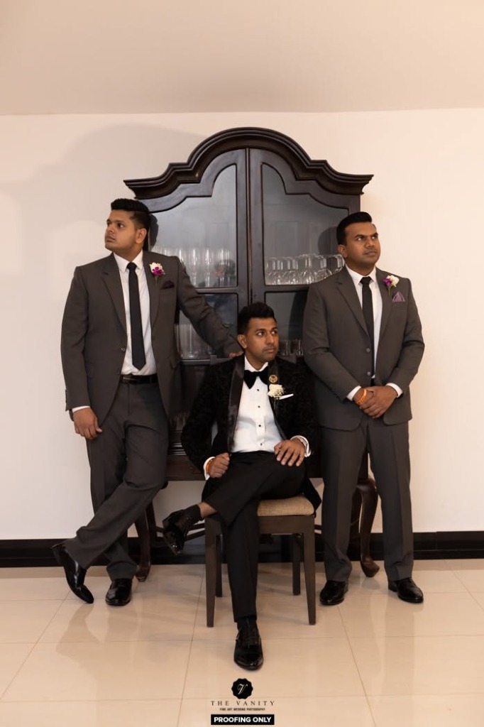 Matching charcoal groomsmen suits with velvet tuxedo